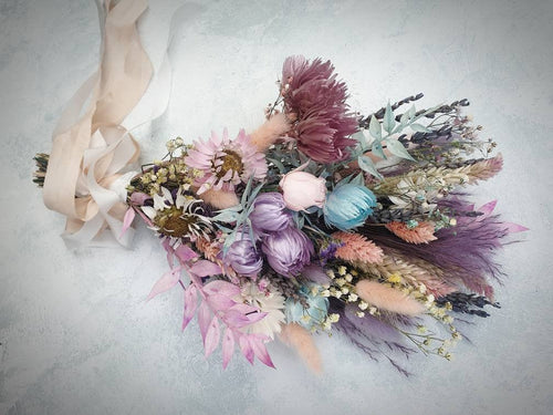 A sheaf style dried flower wedding bouquet in pastel colours